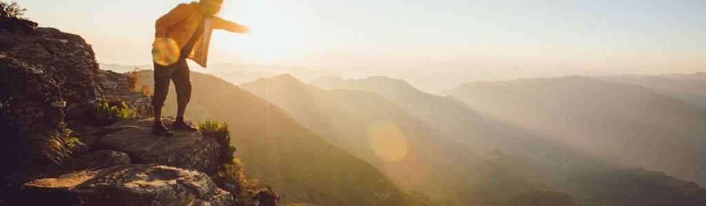 A person admires the sunrise from a scenic cliffside at Cuatro Palos, Mexico.