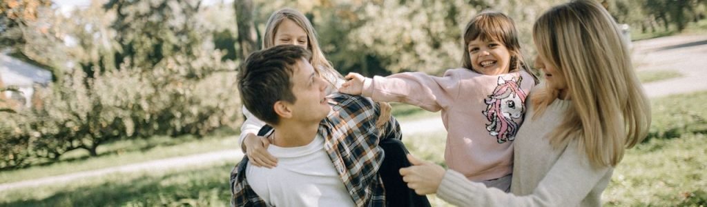 A joyful family spending quality time together in a green park on a sunny day.