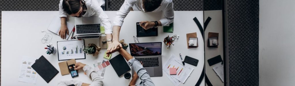 High angle view of colleagues collaborating around a conference table in a modern office setting.